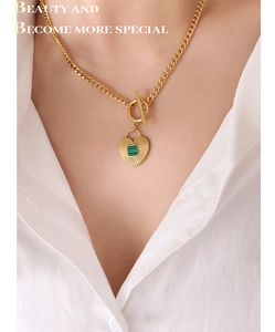 Close-up of heart pendant necklace with green inlay and OT toggle clasp on model