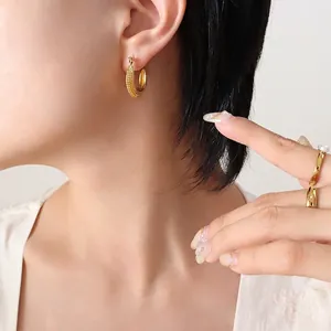 Boucles d'oreilles créoles rétro en forme de C plaqué or 18K portées par un mannequin