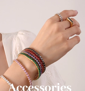Close-up of stacked 18K gold plated titanium bracelets with multi-color zircon stones