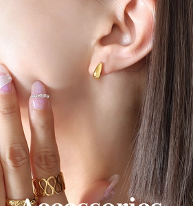 Detailed close-up of a gold waterdrop stud earring with a polished mirror finish on ear