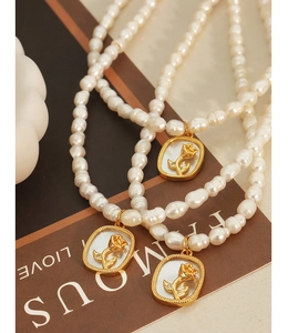 Détails de colliers en perles baroques avec relief de rose dorée sur pendentif en nacre