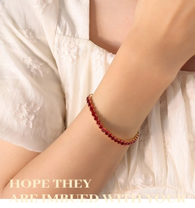 Detailed view of 18K gold plated tennis bracelet with sparkling red round zircons