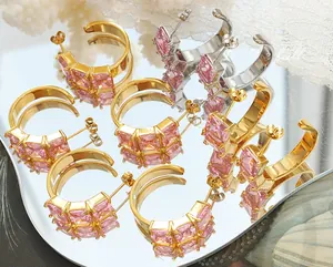 Detail of C-shaped earrings with double-row pink square-cut zircons on a lace background