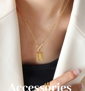 Detail of 18K gold-plated square pendant with sailboat relief and stylish OT toggle clasp