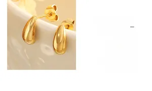 Detailed view of polished golden water drop earrings featuring a smooth mirror-like finish