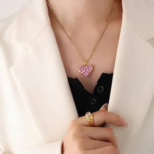 Halskette mit rosa Herzanhänger und Goldring-Set an Model für ein elegantes Styling