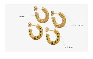 Détail de boucles d'oreilles en C plaquées or 18 carats avec incrustations de zircon