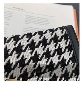 Détail du portefeuille pied-de-poule avec texture de tissu et bouton pression doré