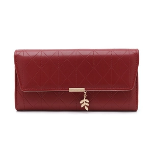 Detail of burgundy long wallet with leaf pendant and quilted pattern on flap