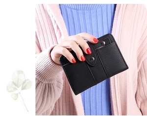 Close-up of black litchi pattern leather wallet with multiple card slots and metal snap