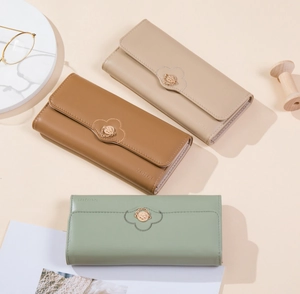 Detailed view of three long PU leather wallets with petal stitching and floral metal charms