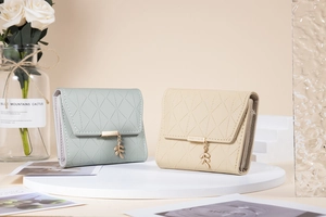 Close-up of quilted leather wallets with gold leaf charms and elegant metal branding
