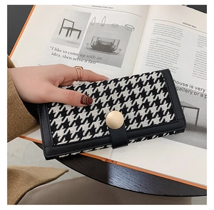 Détail d'un portefeuille long pour femme à motif pied-de-poule avec bouton doré chic