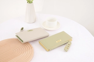 Detailed view of long leather wallets with heart hardware and textured finish