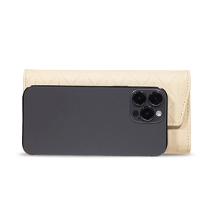 Detailed view of beige quilted leather long wallet next to a phone for size comparison