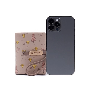 Short PU leather wallet with forest mushroom print and metal buckle next to phone