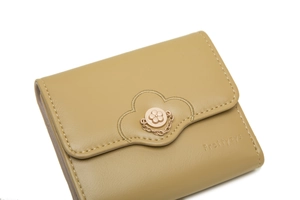 Detail of khakhi tri-fold wallet featuring flower clasp and Prettyzys logo