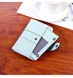 Close-up of mint green faux leather wallet with card slots and a transparent ID window