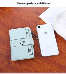 Mint green leather wallet size comparison with smartphone on a wooden table