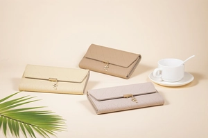 Detailed view of long PU leather wallets with quilted pattern and gold leaf charm