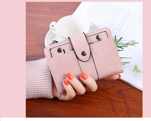Close-up of pink PU leather wallet featuring metal stud buttons and secure zipper details