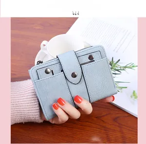 Detail of light blue lychee pattern leather wallet with rivet studs and card slots