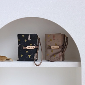 Close-up of PRETTYZYS zip wallets with forest mushroom prints and wrist straps