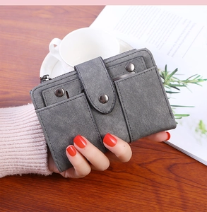Detail view of a vintage dark gray wallet with card slots and metal stud hardware