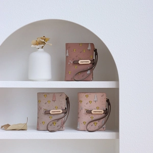 Detailed view of PU leather wallets with mushroom prints and wrist straps in soft colors