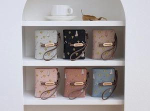 Close-up of printed PU wallets with mushroom patterns and wristlets on display