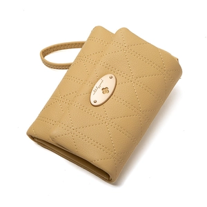 Detail of tan quilted faux leather wallet with gold metal plate and wrist strap handle