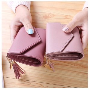 Close-up of pink folding wallets featuring heart tassels and fine stitching detail