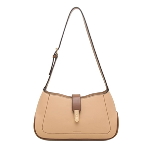 Detail of beige pebbled leather shoulder bag with brown edges and heart-shaped gold hardware