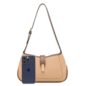 Chic beige underarm bag with brown trim and heart-shaped lock, shown with phone for scale