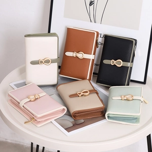 Detail showing the textured cross-grain PU leather and elegant golden metal buckle on the wallet