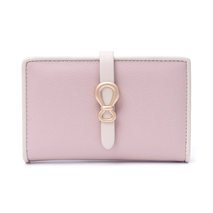 Close-up of pink leather wallet with cream strap and gold butterfly buckle detail