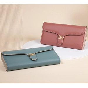 Close-up of elegant long PU leather wallets in pink and green with gold floral buckles