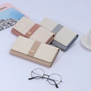 Detail of long PU leather wallets with clover pattern and gold oval twist lock closure