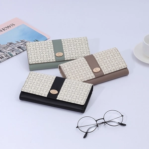 Detailed view of women's long PU leather wallets with clover patterns and metal twist locks