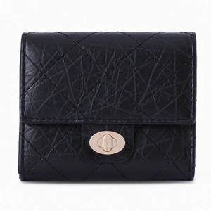 Détail du portefeuille en cuir matelassé noir avec finition vintage et fermoir doré