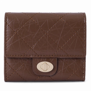 Détail d'un portefeuille en cuir marron matelassé avec fermoir rotatif doré