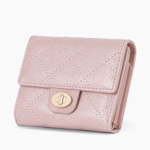 Détail d'un portefeuille matelassé rose avec fermoir doré rotatif et structure multicouche