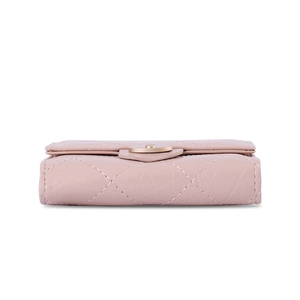 Détail du portefeuille en cuir matelassé rose clair avec boucle en métal doré et couture