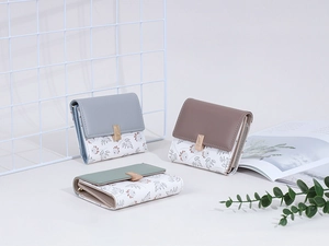 Short tri-fold women's wallet with floral patchwork design and gold buckle detail