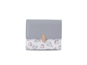 Close-up of floral print trifold wallet featuring an engraved rose gold metal buckle clasp