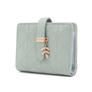 Detail of mint green card holder with diamond quilting and metallic leaf pendant