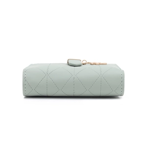 Detail of mint green RFID wallet featuring leaf buckle and quilted diamond stitching