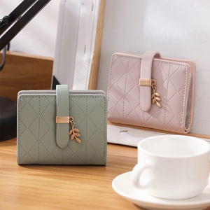 Detail of PU leather RFID wallets featuring leaf pendants and quilted stitch patterns