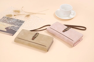 Close-up of vintage matte wristlet wallets in soft pink and khaki with metal clasp