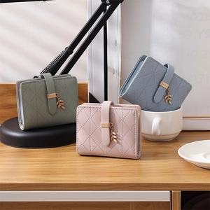 Three quilted PU leather RFID wallets in pastel colors with metal leaf charms